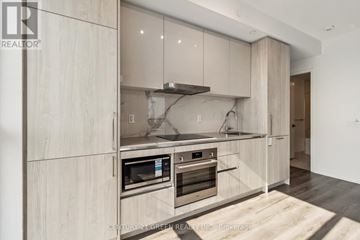 Vaughan (Vaughan Corporate Centre) condo for rent - A modern kitchen with wooden cabinets and stainless steel appliances.