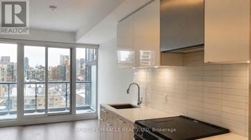 Toronto (Church-Yonge Corridor) condo for rent - A modern kitchen with a large window overlooking a cityscape.