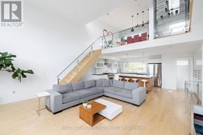 Toronto (Kensington-Chinatown) townhouse for rent - A living room with a grey sofa and a wooden coffee table.