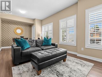 Vaughan (Kleinburg) apartment for rent - A black leather sofa with blue pillows in a living room.