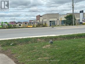 Brampton (Vales Of Castlemore) apartment for rent - A grassy area in front of a road with a sign for REMAX WEST REALTY INC. Brokerage.