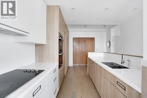 Vancouver apartment for rent - A modern kitchen with a stove top oven and a sink.