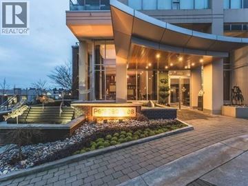 Burnaby apartment for rent - A modern building with a glass entrance and a sign that reads "REALTOR".