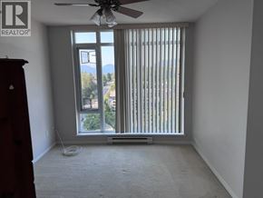 Burnaby apartment for rent - A room with a window covered by vertical blinds and a ceiling fan.
