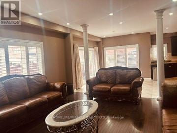 Brampton (Bram East) apartment for rent - A living room with brown leather furniture and a glass table.