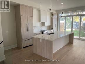 Toronto (Long Branch) apartment for rent - A kitchen with wooden cabinets and a marble countertop.