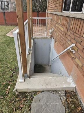 Mississauga (Churchill Meadows) apartment for rent - A small concrete stairway with a wooden handrail leads to a basement door.