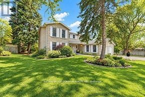 Mississauga (Sheridan) apartment for rent - A large house with a well-manicured lawn and trees in the background.