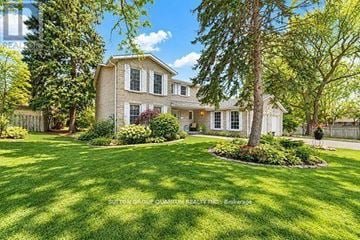 Mississauga (Sheridan) apartment for rent - A large house with a well-manicured lawn and trees in the background.