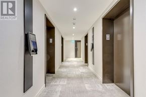 Mississauga (City Centre) condo for rent - A hallway with elevator doors on the right and a realtor sign on the left.