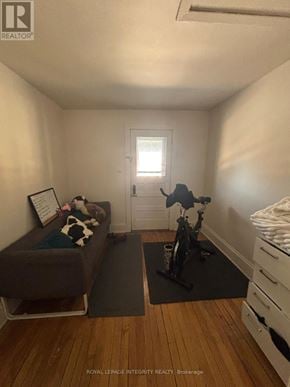 Ottawa townhouse for rent - A small room with a couch, a bicycle, and a baby's crib.