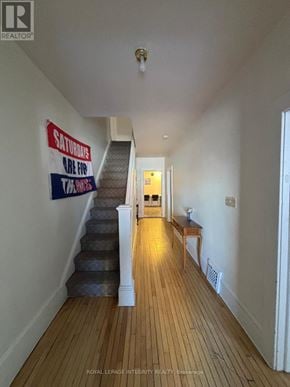 Ottawa townhouse for rent - A long hallway with a staircase and a sign on the wall.