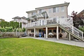Surrey apartment for rent - A house with a white fence and a green lawn.