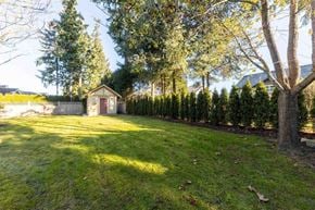 Surrey apartment for rent - A small house is surrounded by a hedge and trees.