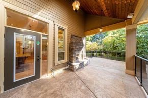 Surrey apartment for rent - A patio with a black door and a stone fireplace.