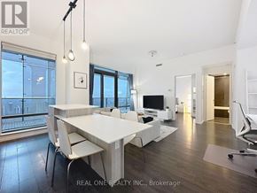 Toronto (Bay Street Corridor) condo for rent - A white dining table with chairs is in a room with a large window.