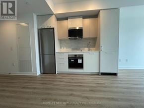 Toronto (Regent Park) condo for rent - A kitchen with white cabinets and a black fridge.
