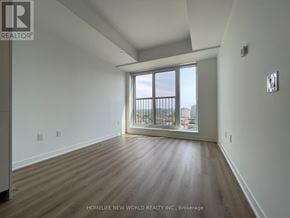 Toronto (Regent Park) condo for rent - A room with wooden floors and a large window overlooking a cityscape.