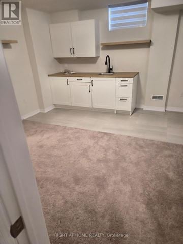 Clarington (Newcastle) apartment for rent - A kitchen with white cabinets and a sink.