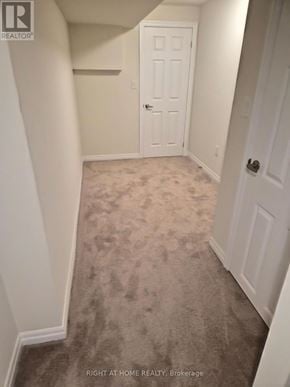 Clarington (Newcastle) apartment for rent - A hallway with a carpeted floor and white walls.