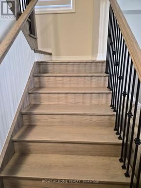 Clarington (Newcastle) apartment for rent - A staircase with wooden steps and black metal railings.
