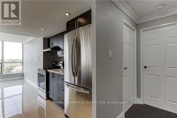 Toronto (Mount Olive-Silverstone-Jamestown) condo for rent - A modern kitchen with a stainless steel refrigerator and white cabinets.