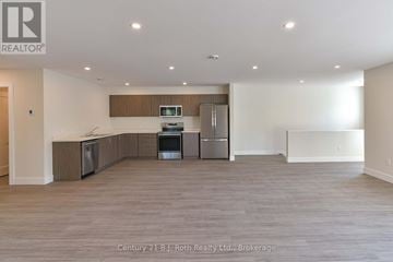 Orillia triplex for rent - A spacious kitchen with wooden cabinets and stainless steel appliances.