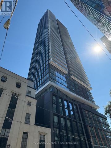 Toronto (Church-Yonge Corridor) condo for rent - A tall building with a glass facade stands next to a building with a white facade.
