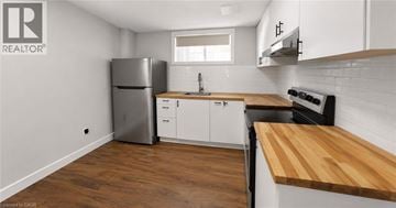 Hamilton apartment for rent - A kitchen with white cabinets and a wooden counter top.
