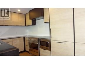 Vancouver apartment for rent - A kitchen with wooden cabinets and a black countertop.