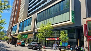 Toronto (Bay Street Corridor) condo for rent - A street view of a city with cars, buildings, and people.