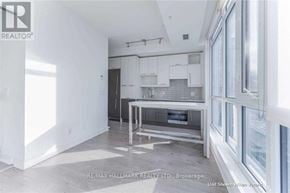 Toronto (Waterfront Communities) condo for rent - A white kitchen with a table and chairs in the middle of the room.