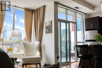 Toronto (North St. James Town) condo for rent - A living room with a view of the city through the windows.