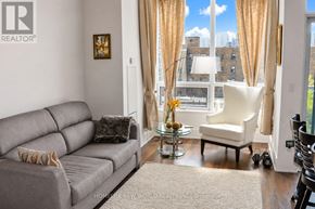 Toronto (North St. James Town) condo for rent - A living room with a grey sofa, a glass coffee table, and a window with curtains.