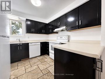 Aurora (Aurora Highlands) townhouse for rent - A kitchen with black cabinets and a white dishwasher.