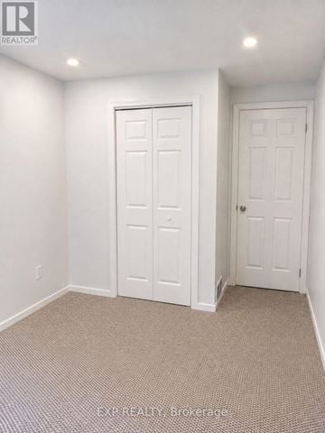 Oshawa (O'neill) townhouse for rent - A room with two white doors and carpeted flooring.