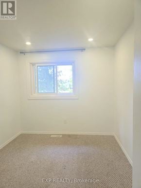 Oshawa (O'neill) townhouse for rent - A room with a window and carpeted floor.