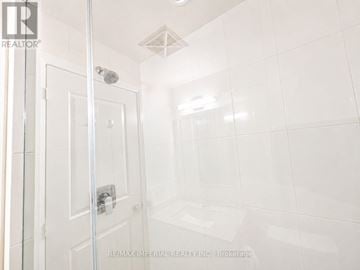 Mississauga (Hurontario) condo for rent - A white tiled bathroom with a glass shower door.
