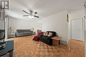 Guelph (Junction/Onward Willow) condo for rent - A living room with a black couch and a wooden floor.