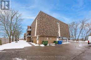 Guelph (Junction/Onward Willow) condo for rent - A building with a parking lot in front of it.