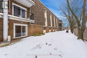 Guelph (Junction/Onward Willow) condo for rent - A snow-covered street in front of a brick building.
