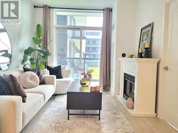 Mississauga (Hurontario) condo for rent - A living room with a white couch and a coffee table in front of a fireplace.