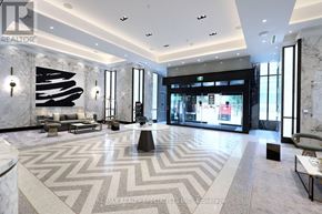 Toronto (Waterfront Communities) condo for rent - A spacious lobby with a marble floor and a large abstract painting on the wall.