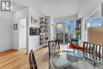 Toronto (North St. James Town) condo for rent - A living room with a glass table and a view of the city.