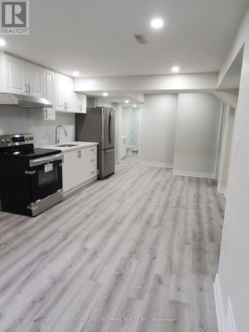 Milton (Ha Harrison) apartment for rent - A well-lit kitchen with a refrigerator, stove, and sink.