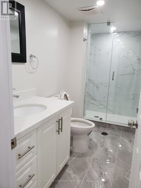 Milton (Ha Harrison) apartment for rent - A white bathroom with a marble floor and a glass shower door.