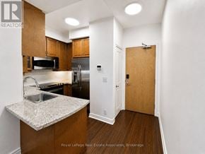 Toronto (South Parkdale) condo for rent - A kitchen with wooden cabinets and a sink.