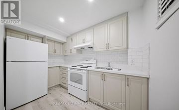 Brampton (Fletcher's Meadow) apartment for rent - A white kitchen with a refrigerator, oven, and sink.