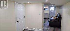 Toronto (Weston-Pellam Park) apartment for rent - A white door is in a hallway with a couch and a chair.