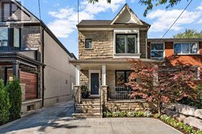 Toronto (Weston-Pellam Park) apartment for rent - A house with a stone facade and a front porch is surrounded by a well-kept garden.